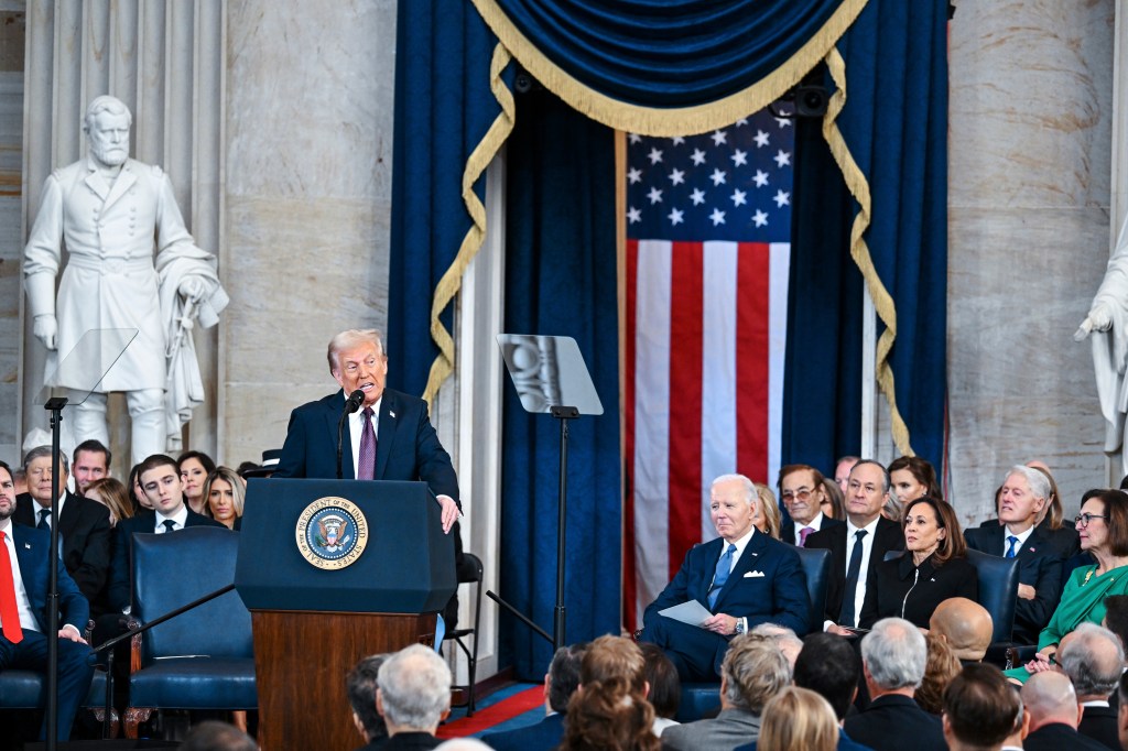 President Donald Trump speaks at his inauguration at the US Capitol, with a crowd of people in the background, after being sworn into office.